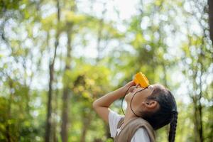 Happy Little Asian girls looking ahead and smiling child with the binoculars in the park. Travel and adventure concept. Freedom, vacation photo