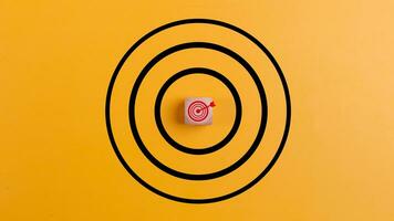 Concept of success. Target with a target icon on a wooden block on a yellow background the concept of achieving or targeting business goals. photo