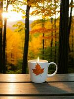 Cup of hot tea with autumn leaves on wooden table in forest photo