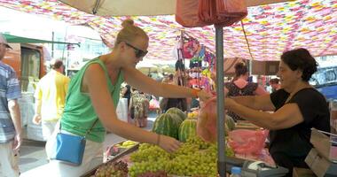 jovem mulher escolhendo uvas antes comprando video