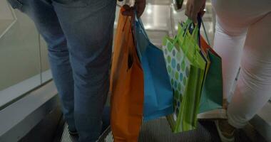 Couple with shopping bags riding escalator video