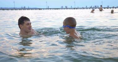 garçon nager dans le mer avec Parents video