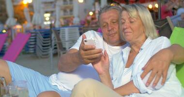 Couple sitting and looking at phone video