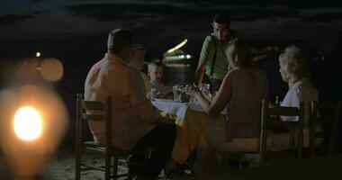 Waiter serving dinner for family in outdoor cafe video
