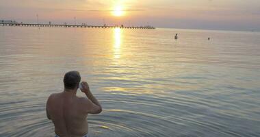 retour vue de homme parlant plus de téléphone tandis que en train de regarder le coucher du soleil video