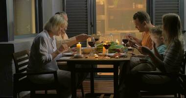 Big family having meal in late evening video