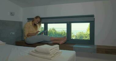 Frau mit Pad durch das Fenster im Hotel video