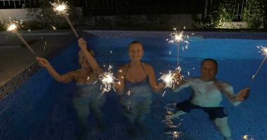 firande med sparklers i de simning slå samman video