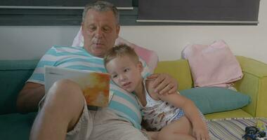 Grandfather and grandchild with laptop at home video