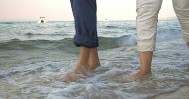 couple en marchant dans entrant mer vagues video