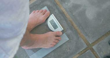 Man weighing himself on bathroom scales video