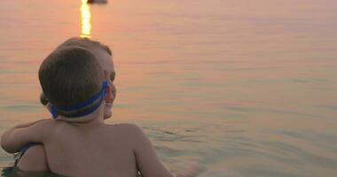 madre e hijo nadando juntos en el mar video