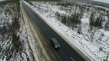 Aerial view of minivan driving winter road video