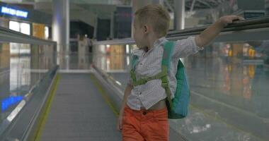 schattig weinig jongen Aan roltrap in luchthaven video