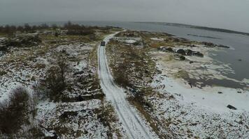 Flying over minivan driving on winter shore video