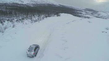 Aerial view of car driving on snowy mountain road video