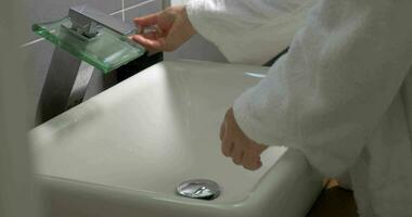 Woman washing hands with soap in the bathroom video