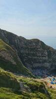 People at Most Beautiful High Angle View of British Landscape and Sea View of Durdle Door Beach of England Great Britain, UK. Image Was captured with Drone's camera on September 9th, 2023 video