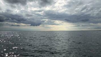 spectaculaire paysage marin, foncé des nuages plus de le mer, horizon, coup de une bateau dans mouvement video