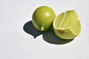 lleno limón y medio limón en blanco antecedentes. foto