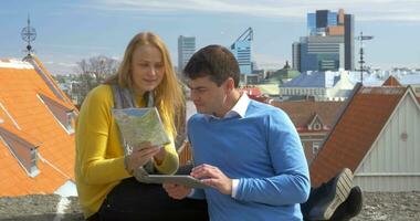 Mens en vrouw gebruik makend van stootkussen en kaart in stad video