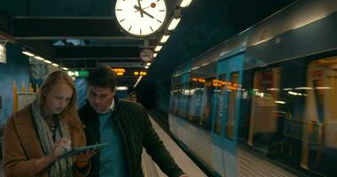 två pendlare använder sig av läsplatta pc på metro station video