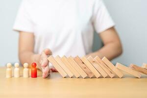 Hand stop falling wood domino blocks on table. Crisis, fall Business, Risk management, Economic recession, Strategy and solutions concept photo