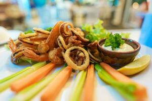 Italian dish fried seafood, octopus, shrimp, squid and lemon sliced. Italy fast food and appetizers photo