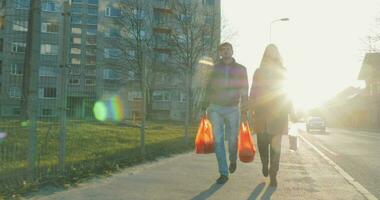 Couple with bags going home after shopping video