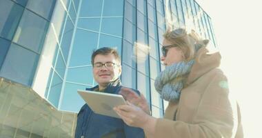 jeunes marchant dans la ville et utilisant un pad video