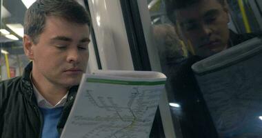 Mann mit Zeitung im U-Bahn-Zug unterwegs video