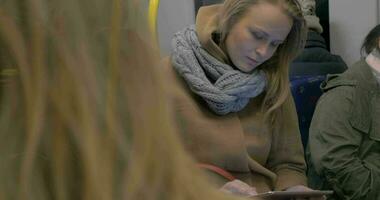 Young woman using tablet computer in subway train video