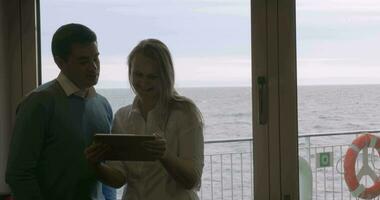 Young couple using tablet PC on board the ship video