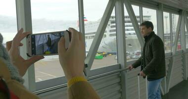 Woman with cell taking picture of a man in dockyard video