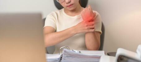 Woman having wrist pain when using laptop computer and mouse during working long time on workplace. De Quervain s tenosynovitis, rheumatism ergonomic, Carpal Tunnel Syndrome or Office syndrome concept photo