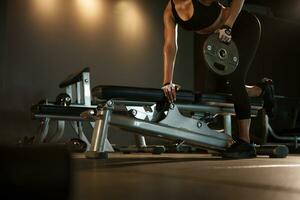 Sporty woman exercising with weight plate in the gym. photo