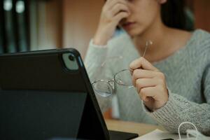 Asian student woman read books in library at university. Young girl stress tired have problem while study hard. Sadness concept photo