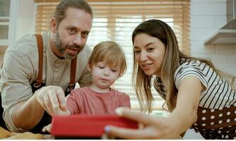 joven amor familia son preparando el desayuno en el cocina. madre tomar un foto selfie por teléfono.