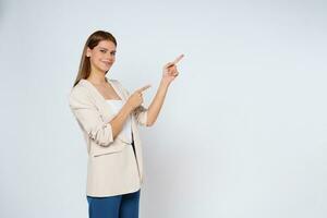 Young  woman pointing to empty copy space isolated on white background. photo