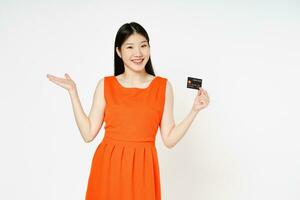 Young woman smiling, showing, presenting credit card for making payment or paying online business isolated on white background. photo