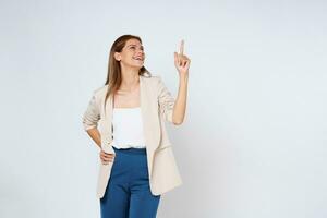 Happy young woman looking above and pointing up to copy space with smile face and happy isolated on white background. photo