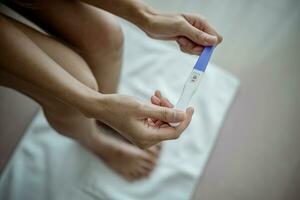 Close-up of young woman holds a pregnancy test in her hands. Positive pregnancy test. photo