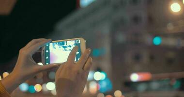 niña con célula teléfono haciendo fotos de noche ciudad video