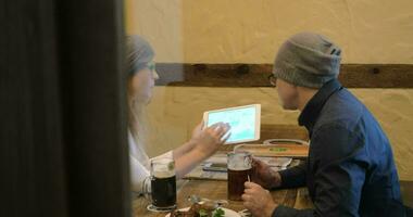 Young people having nice evening with beer and pad video