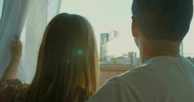 Young couple enjoying city view through the window video