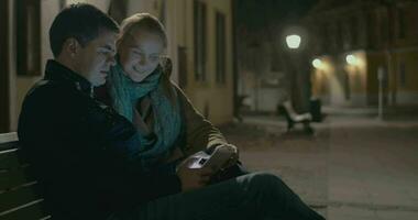 Young couple using pad on the street bench video