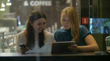 kvinnliga vänner underhållande med pad i café video