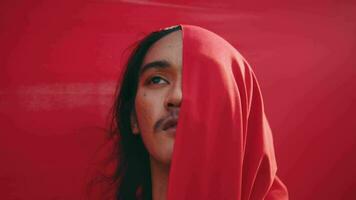 ett asiatisk man bunden och strypt förbi en röd trasa med en sade upp sig ansikte i främre av en röd bakgrund video