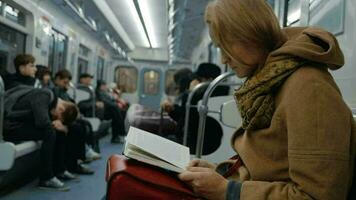 Young woman reading a book in subway video