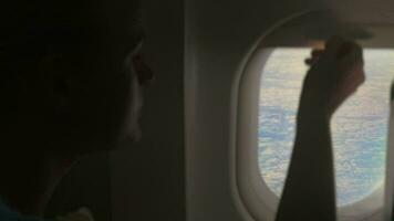 Woman looking out illuminator in plane video